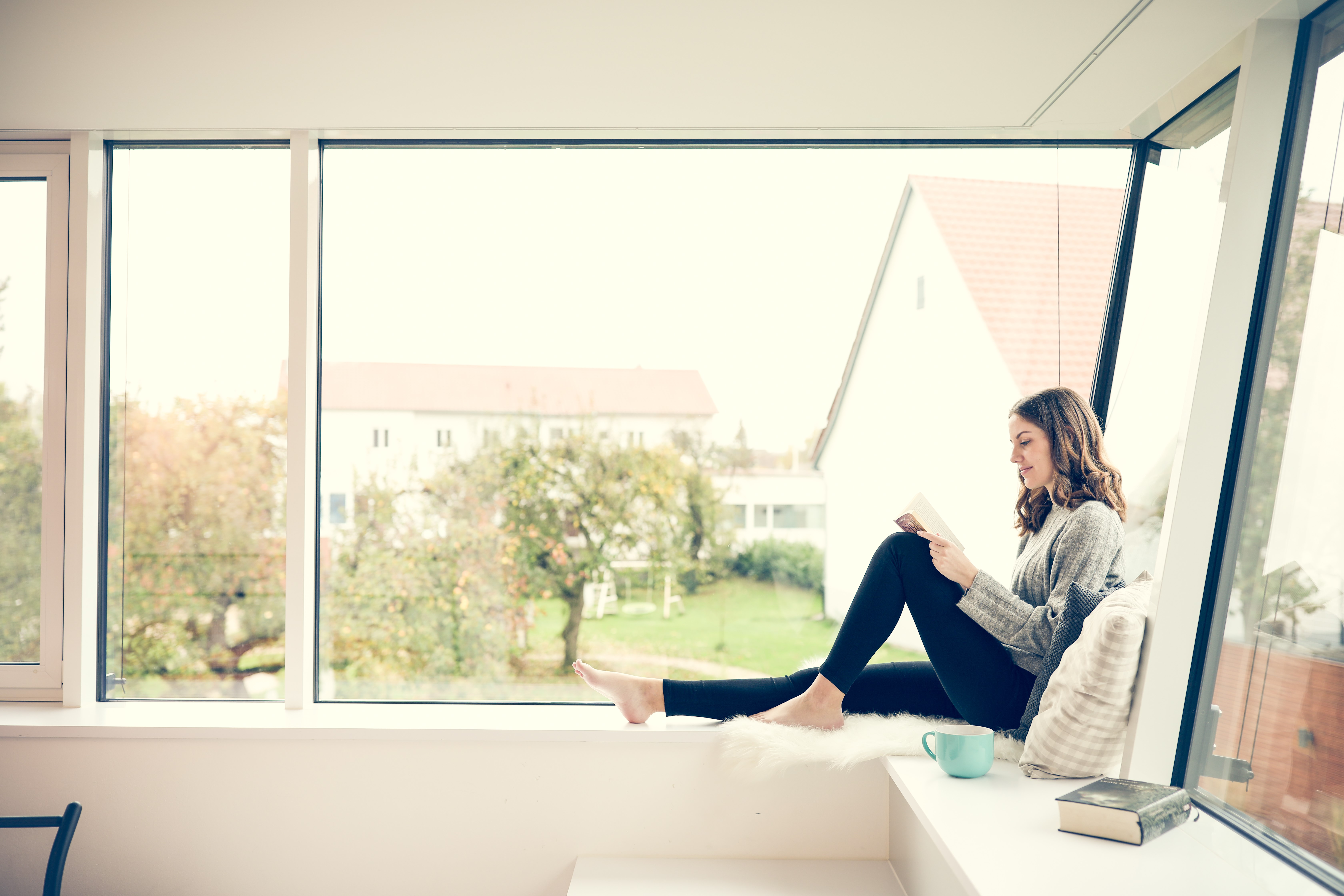 Frau sitzt vor Fenster